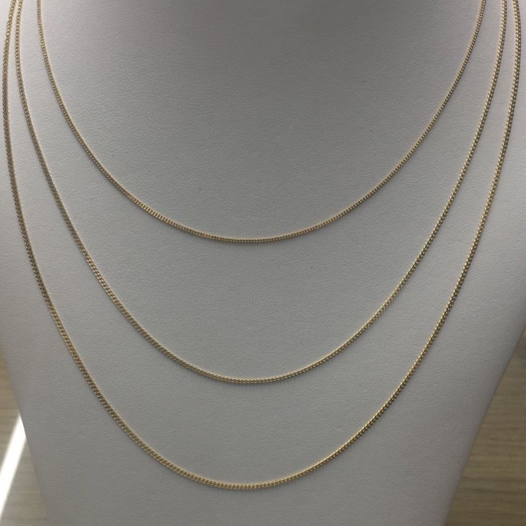 thin curb necklaces in 9kt yellow gold on a mannequin