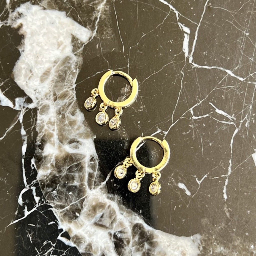 huggie earrings with three hanging charms with cubic zirconias