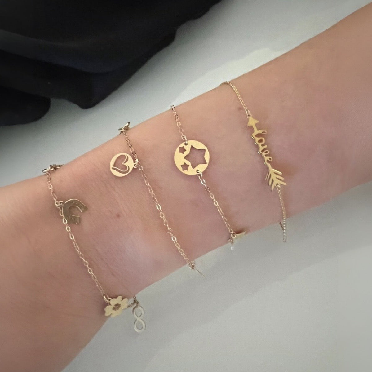 charm bracelet in 9ct yellow gold with horseshoe, flower, infinity, moon and star charm bracelet