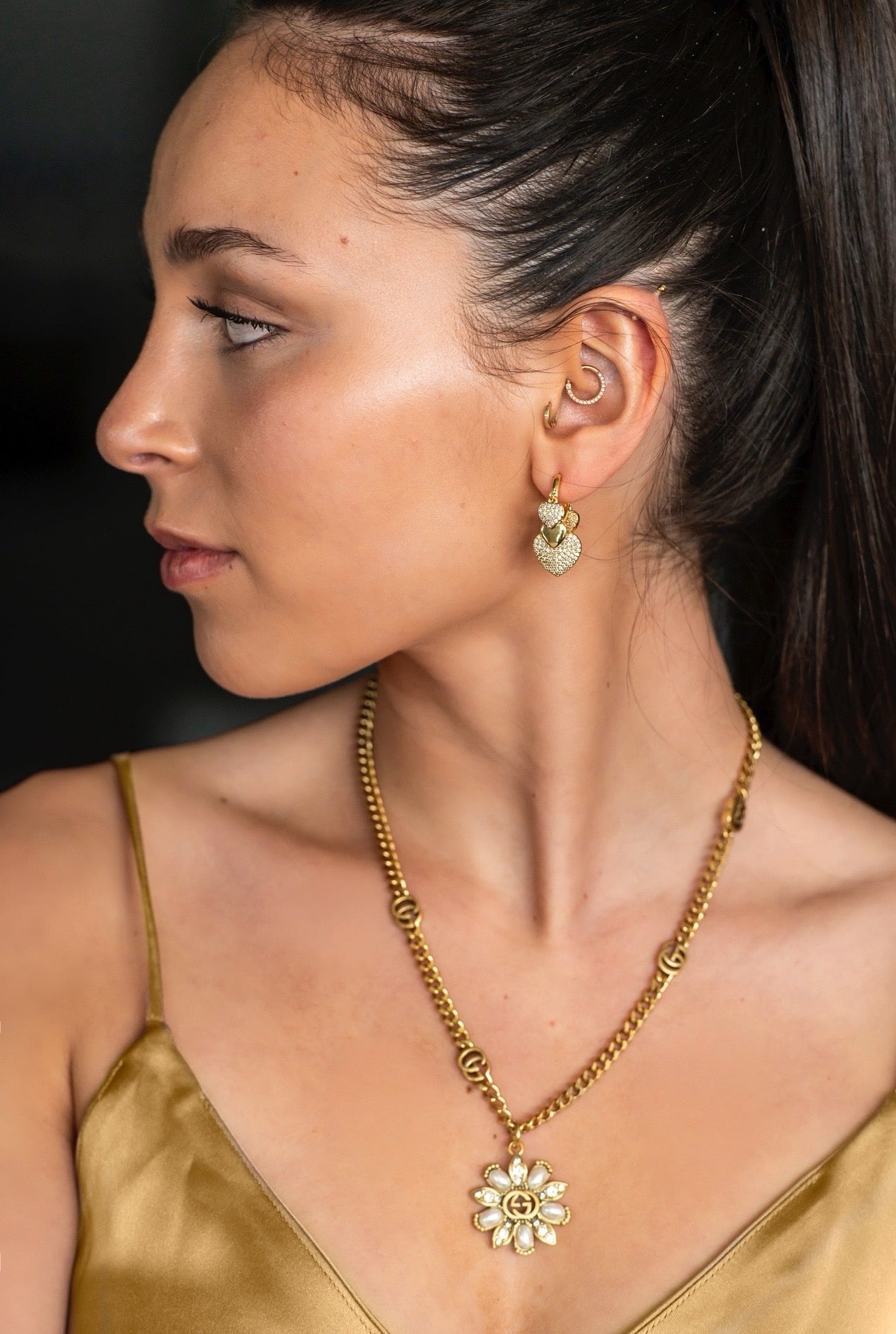 Heart Charm Huggie Earrings in gold with cubic zirconias and flower power necklace on model