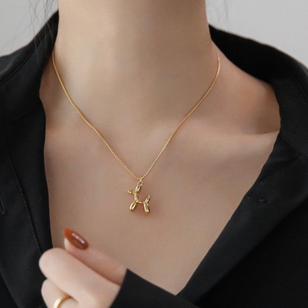 gold balloon dog pendant necklace on model