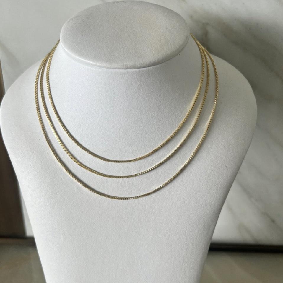 three box chain necklaces layered in 14k gold