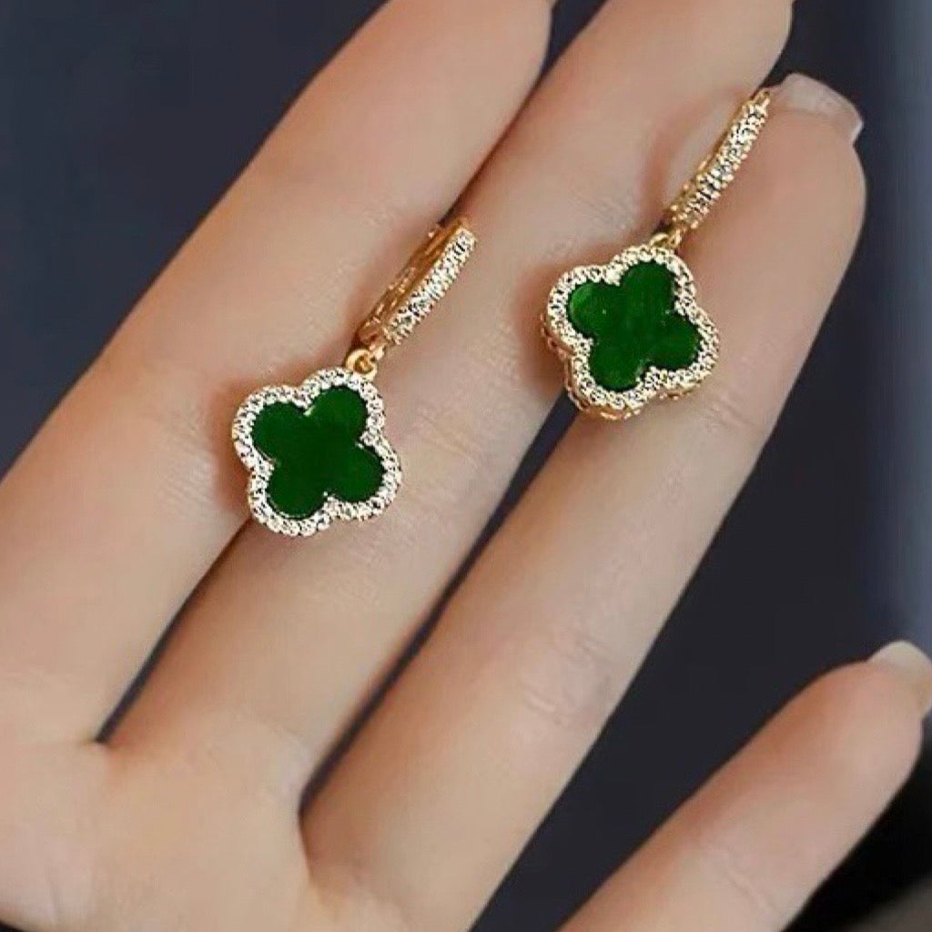 clover earrings green and gold in models hand