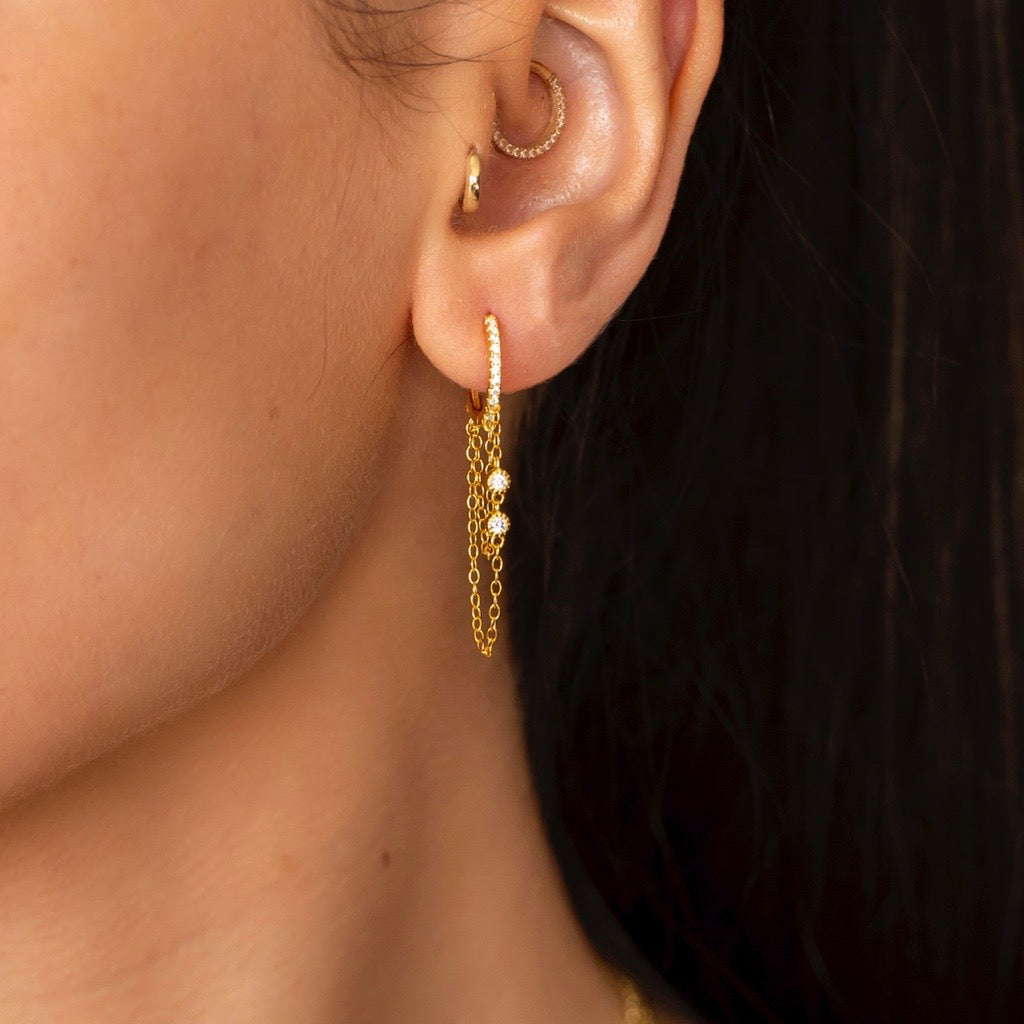 huggie earrings with two chains and embellished with cubic zirconias
