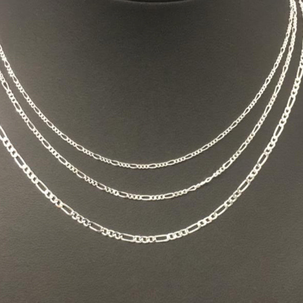 silver figaro necklaces in various widths on mannequin