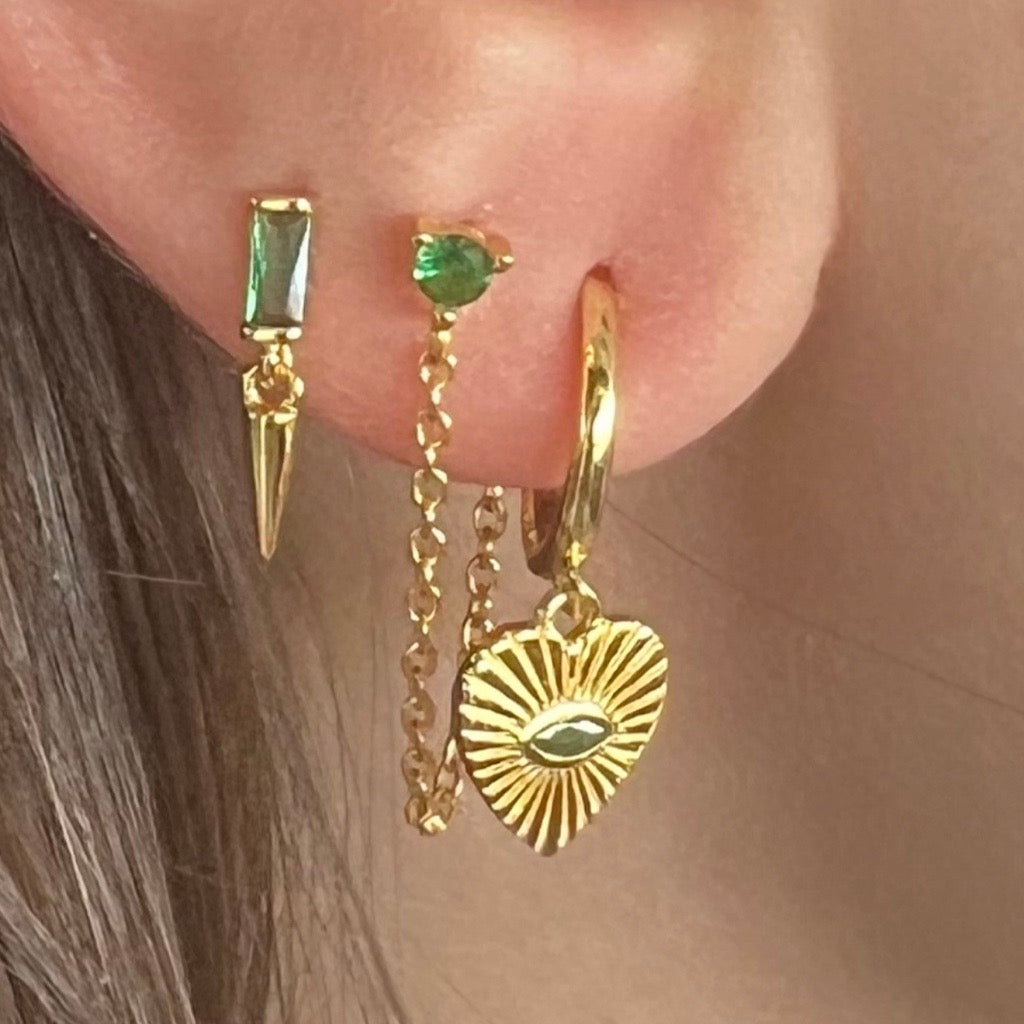 heart huggies with emerald green eye on model with complimentary earrings showing stack