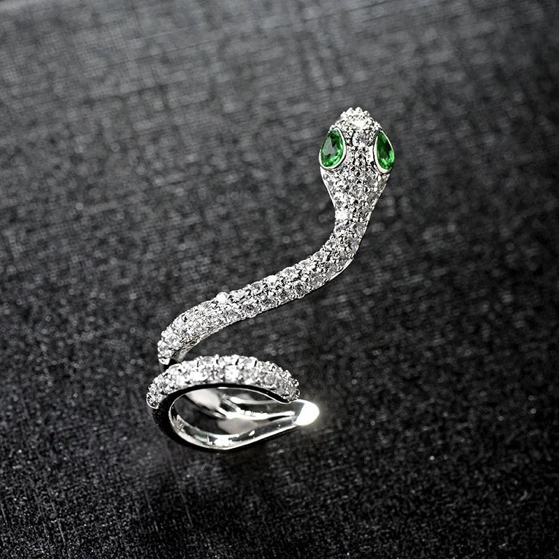 silver snake cuff earring with cubic zirconias and green eyes. sold as a single earring