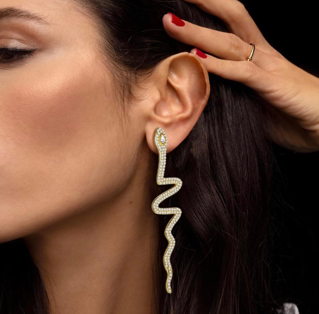 statement snake earrings on model