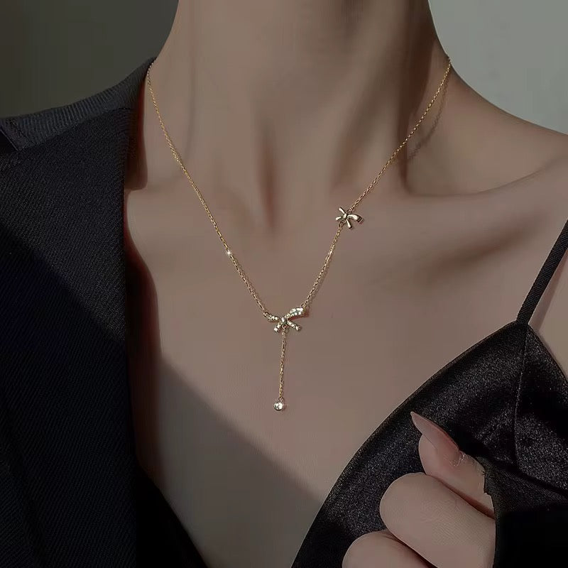 the bow necklace in gold plated with lariat cubic zirconia hanging charm