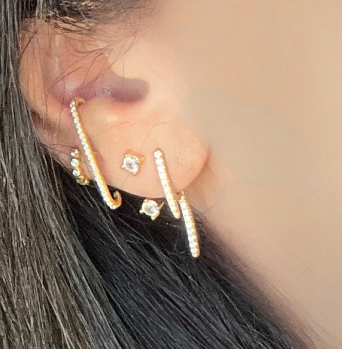 stud earrings with a contemporary elegant two tier aesthetic in gold covered in cubic zirconias